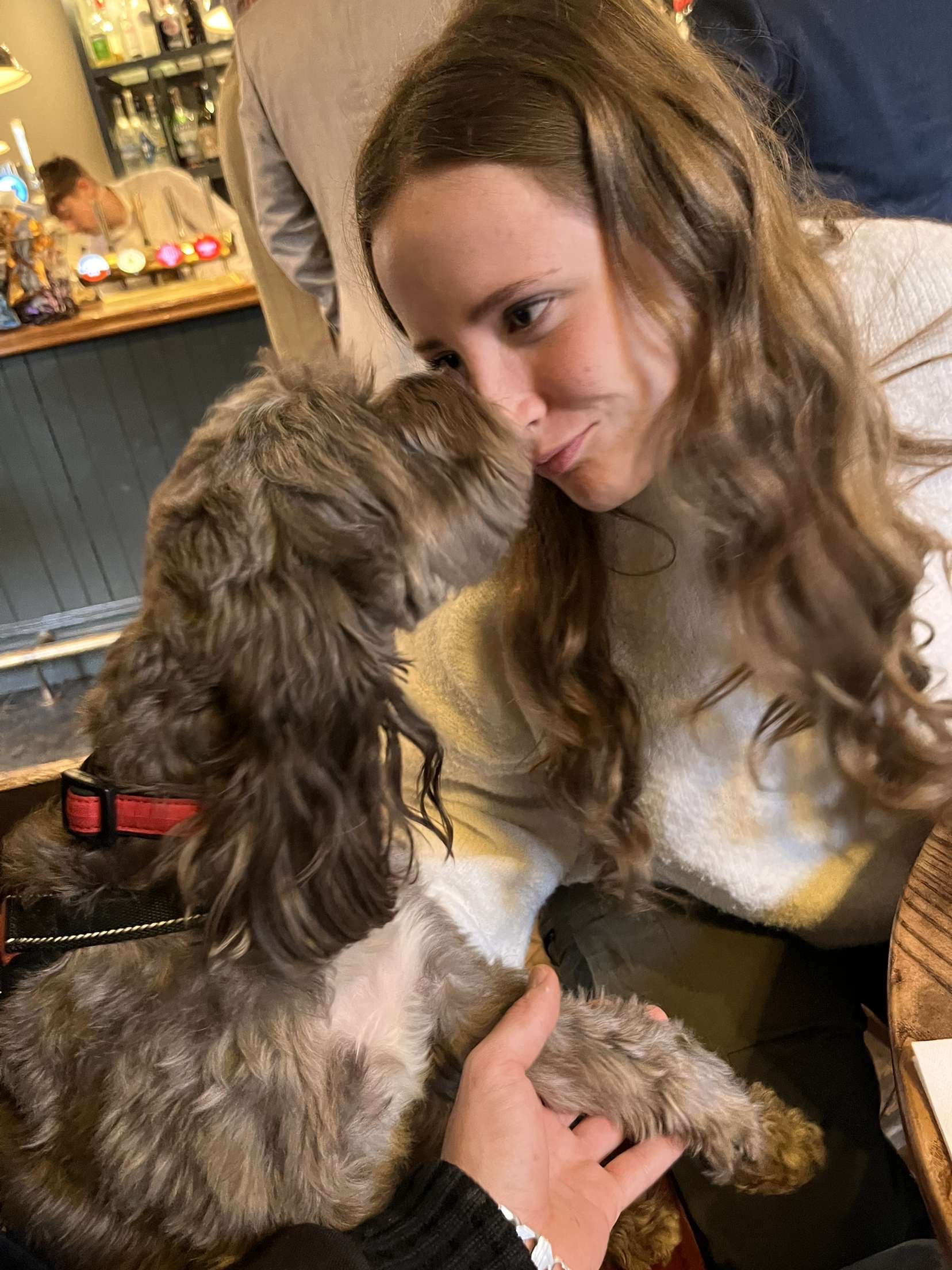 Imi cuddling a dog during a pet care visit